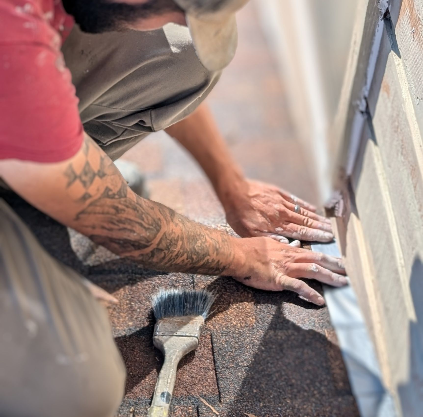 painter using tape to protect shingles during an exterior paint project